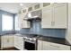 Modern kitchen showcases stainless steel appliances, sleek white cabinetry, and blue subway tile backsplash at 12304 Ridgeside Rd, Indianapolis, IN 46256