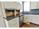Kitchen counter with open beverage refrigerator, sink and blue tile backsplash at 12304 Ridgeside Rd, Indianapolis, IN 46256