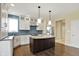 Modern kitchen featuring a center island, a stainless steel refrigerator, and white cabinets with blue subway tile backsplash at 12304 Ridgeside Rd, Indianapolis, IN 46256