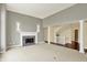 Large open living room with a fireplace, neutral carpet, columns, and staircase at 12304 Ridgeside Rd, Indianapolis, IN 46256
