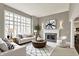 Bright living room with a fireplace, large windows and comfortable furniture at 12304 Ridgeside Rd, Indianapolis, IN 46256