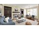 Cozy living room featuring a fireplace, built-in cabinets, a blue sofa, and bright windows overlooking a winter landscape at 12304 Ridgeside Rd, Indianapolis, IN 46256
