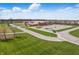 Captured from above, a school building is surrounded by green lawns, parking spaces, and athletic fields at 12536 Lowery Way, Fishers, IN 46037
