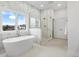 Modern bathroom featuring a freestanding tub, marble walls, and a glass enclosed shower at 12536 Lowery Way, Fishers, IN 46037