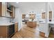 Spacious kitchen featuring wood floors, an island with counter seating, stainless appliances, and modern lighting at 12536 Lowery Way, Fishers, IN 46037