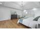 Bright primary bedroom with a tray ceiling, light hardwood floors, and elegant furnishings at 12536 Lowery Way, Fishers, IN 46037