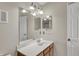 Bathroom featuring a vanity with a solid surface top, mirror, and a white door at 12588 Tennyson Ln # 205, Carmel, IN 46032
