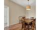 Dining area with view to doorway, wooden table, and pendant light at 12588 Tennyson Ln # 205, Carmel, IN 46032