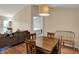 Dining area open to the living room with wooden table and modern lighting at 12588 Tennyson Ln # 205, Carmel, IN 46032