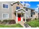 Charming condo exterior with well-maintained landscaping, gray siding, and a vibrant red door at 12588 Tennyson Ln # 205, Carmel, IN 46032