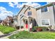 Attractive condo building with lush green lawn, mature bushes, and a welcoming red entry door at 12588 Tennyson Ln # 205, Carmel, IN 46032