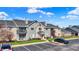 Charming condominium building featuring a red door, balcony, and well-maintained landscaping at 12588 Tennyson Ln # 205, Carmel, IN 46032
