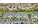 Aerial view of gray condo buildings with red doors, ample parking, and a scenic pond at 12588 Tennyson Ln # 205, Carmel, IN 46032