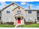 Inviting condo exterior featuring a bright red door, neutral siding, and manicured landscaping at 12588 Tennyson Ln # 205, Carmel, IN 46032