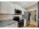 Bright kitchen features stainless steel appliances, white cabinets, and access to the utility room at 12588 Tennyson Ln # 205, Carmel, IN 46032