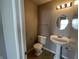 A cozy half bathroom offers pedestal sink, decorative mirror, and standard toilet at 12657 Republic Dr, Fishers, IN 46037