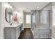 Bright bathroom featuring a double vanity, framed mirrors, decorative lighting, and a glass-enclosed shower at 132 Oakhurst Way, Westfield, IN 46074