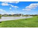 Scenic view of homes surrounding a pond with a fountain and lush green lawn, offering a serene community setting at 132 Oakhurst Way, Westfield, IN 46074