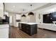 Open kitchen with large island, pendant lighting, stainless steel appliances, and hardwood floors at 132 Oakhurst Way, Westfield, IN 46074