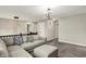 Bright living room with a plush sectional sofa, neutral colors, modern light fixtures, and black railing at 132 Oakhurst Way, Westfield, IN 46074