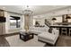 Bright living room with a large sectional sofa, elegant chandelier, and views to the backyard at 132 Oakhurst Way, Westfield, IN 46074