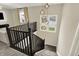 Upstairs view of staircase with neutral colors, dark railing and decorative lighting at 132 Oakhurst Way, Westfield, IN 46074