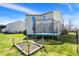 Spacious backyard featuring a trampoline, garden plot, and green grass at 1330 Redwood Dr, Greenfield, IN 46140
