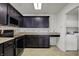 Kitchen with dark cabinets offers efficient workspace with easy access to the laundry and modern appliances at 1330 Redwood Dr, Greenfield, IN 46140