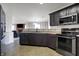 Modern kitchen with stainless steel appliances and dark cabinets offers a seamless view into the living area at 1330 Redwood Dr, Greenfield, IN 46140