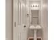 Cozy powder room with a pedestal sink, decorative mirror, and modern lighting creates a welcoming space at 1330 Redwood Dr, Greenfield, IN 46140