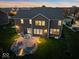 This home boasts a large backyard with a stone patio, a built-in fire pit, and beautiful exterior lighting at 13314 Lansbury Ln, Fishers, IN 46037