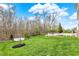 Picture of a large, well-maintained backyard with green grass, mature trees, and a mulch bed in the foreground at 13314 Lansbury Ln, Fishers, IN 46037