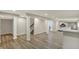 Open basement layout with white support pillars, hardwood floors, and a modern kitchenette bar at 13314 Lansbury Ln, Fishers, IN 46037