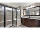 Elegant bathroom showcasing a walk-in shower with glass doors, a large mirror, and a granite vanity at 13314 Lansbury Ln, Fishers, IN 46037