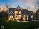 Beautiful two-story brick home with manicured lawn, professional landscaping, and exterior lighting at 13314 Lansbury Ln, Fishers, IN 46037