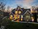 Charming two-story brick home with manicured lawn, mature trees, professional landscaping, and exterior lighting at 13314 Lansbury Ln, Fishers, IN 46037