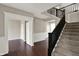 Bright foyer with hardwood floors, staircase with dark railing, and neutral wall colors at 13314 Lansbury Ln, Fishers, IN 46037