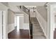 Bright foyer with hardwood floors, staircase with dark railing, and white trim at 13314 Lansbury Ln, Fishers, IN 46037