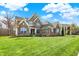 Beautiful two story brick home with a manicured lawn, large windows, and covered front porch at 13314 Lansbury Ln, Fishers, IN 46037