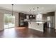 Kitchen featuring dark cabinets, center island with seating, stainless steel appliances, and a patio access at 13314 Lansbury Ln, Fishers, IN 46037
