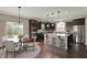 Eat-in kitchen featuring dark cabinets, a center island with seating, and stainless steel appliances at 13314 Lansbury Ln, Fishers, IN 46037