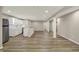 Open concept living area showcasing a kitchenette, hardwood floors, and white support pillars at 13314 Lansbury Ln, Fishers, IN 46037