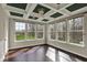 Bright living room featuring coffered ceiling with dark green accents and hardwood floors at 13314 Lansbury Ln, Fishers, IN 46037