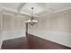 Open living room with wainscoting, dark hardwood floors, and modern chandelier at 13314 Lansbury Ln, Fishers, IN 46037