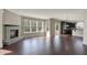 Open-concept living room features a stone fireplace, hardwood floors, and access to the kitchen at 13314 Lansbury Ln, Fishers, IN 46037