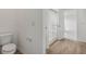 Bathroom featuring a toilet, shower with glass doors, and wood-look flooring at 13418 Vickery Ridge Dr, Fishers, IN 46037