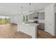 Open kitchen with island, stainless appliances, gray cabinets, and wood floors at 13418 Vickery Ridge Dr, Fishers, IN 46037