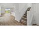 Open-concept living area with kitchen, dining, and staircase access with sliding glass door to backyard at 13418 Vickery Ridge Dr, Fishers, IN 46037