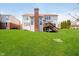 Expansive backyard with a well-maintained lawn and a cozy wooden deck accessible by stairs from the home at 13933 Wildcat Dr, Carmel, IN 46033