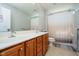 Bathroom featuring double sink vanity with wood cabinets and a shower-tub combo at 13933 Wildcat Dr, Carmel, IN 46033